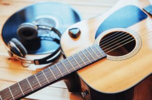 Klassische Gitarre mit Kopfhörern auf einem Holzhintergrund