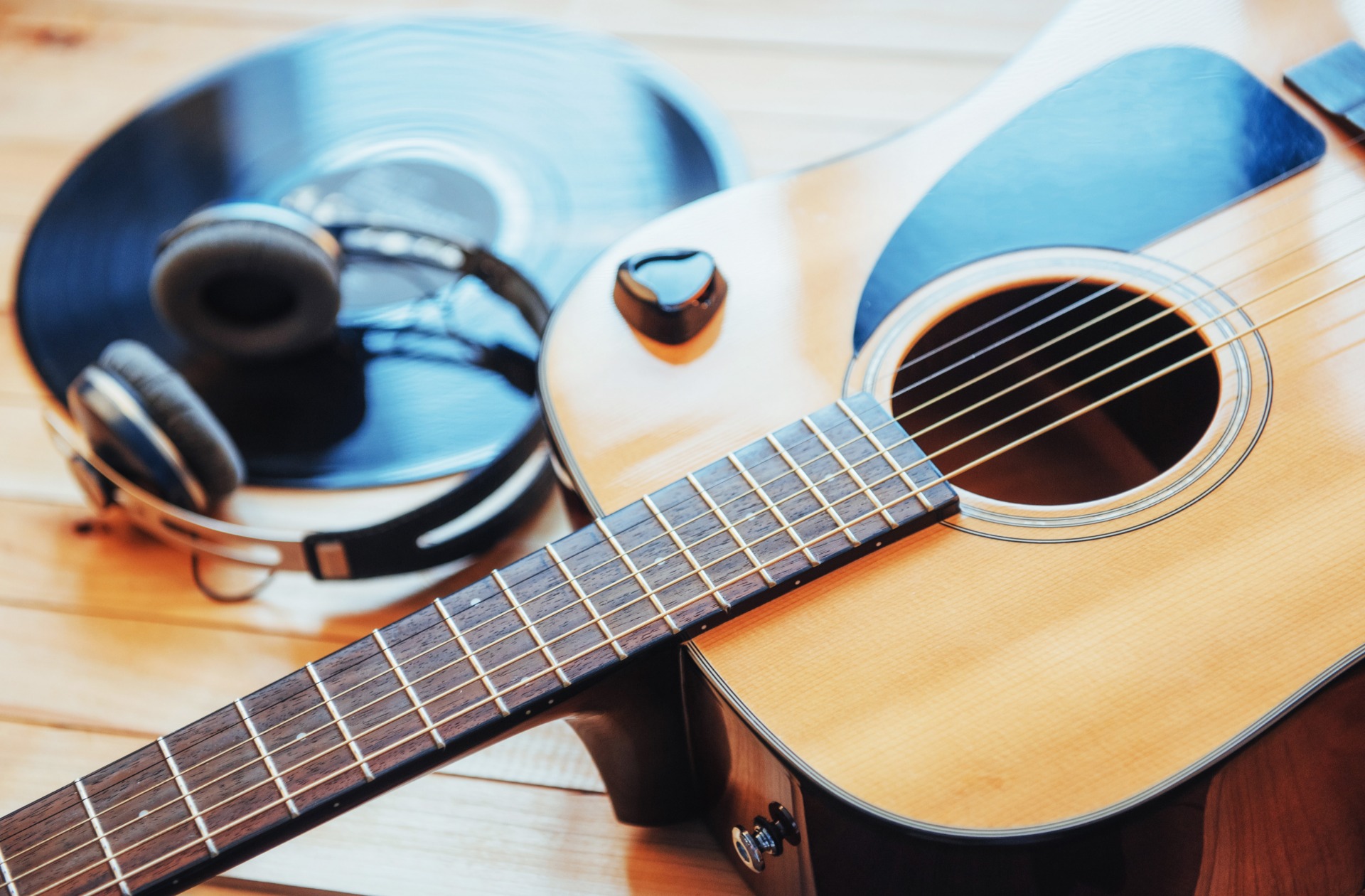 Klassische Gitarre mit Kopfhörern auf einem Holzhintergrund
