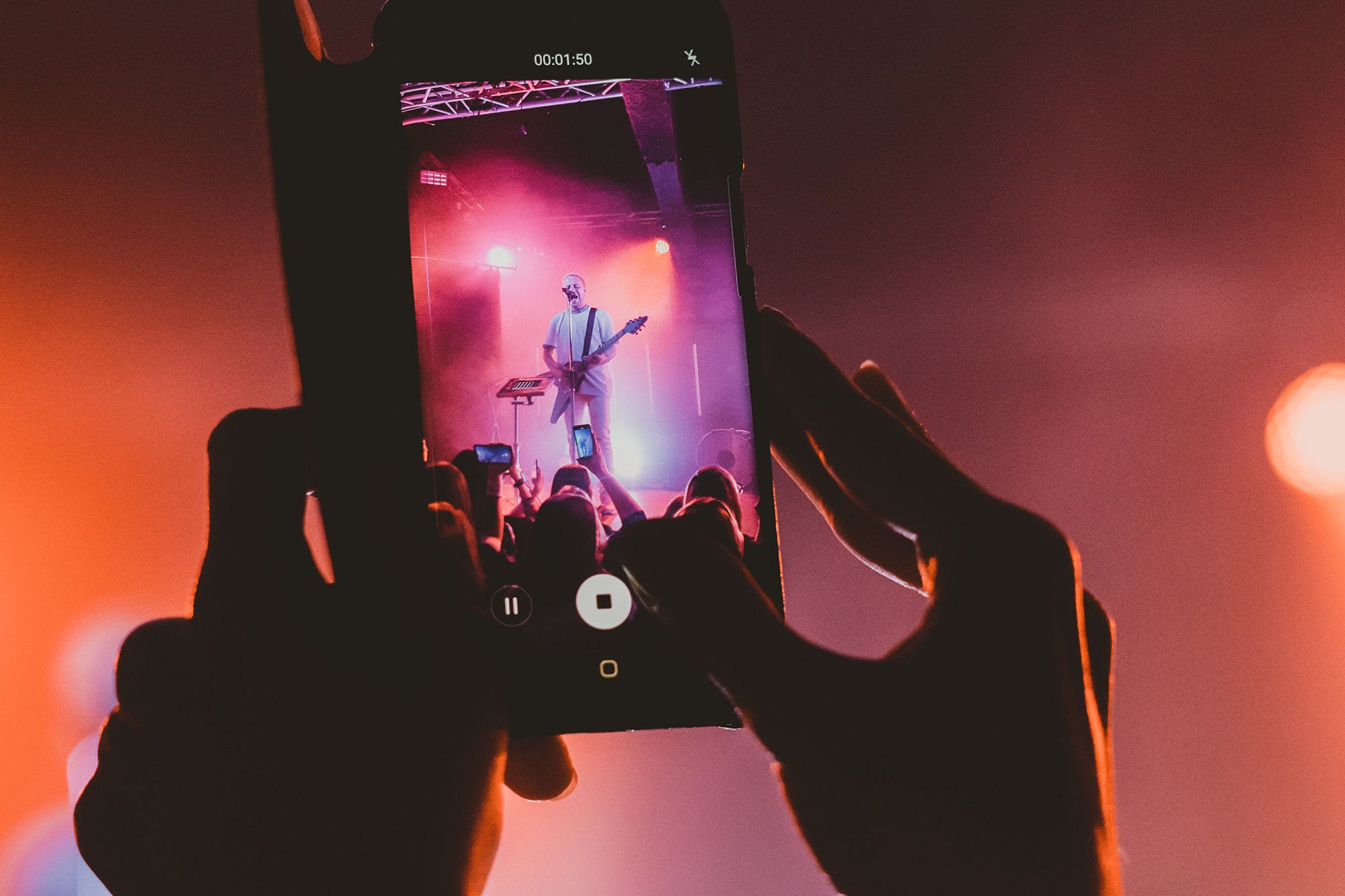 Musiker spielt Gitarre und singt auf der Bühne / Live-Konzert