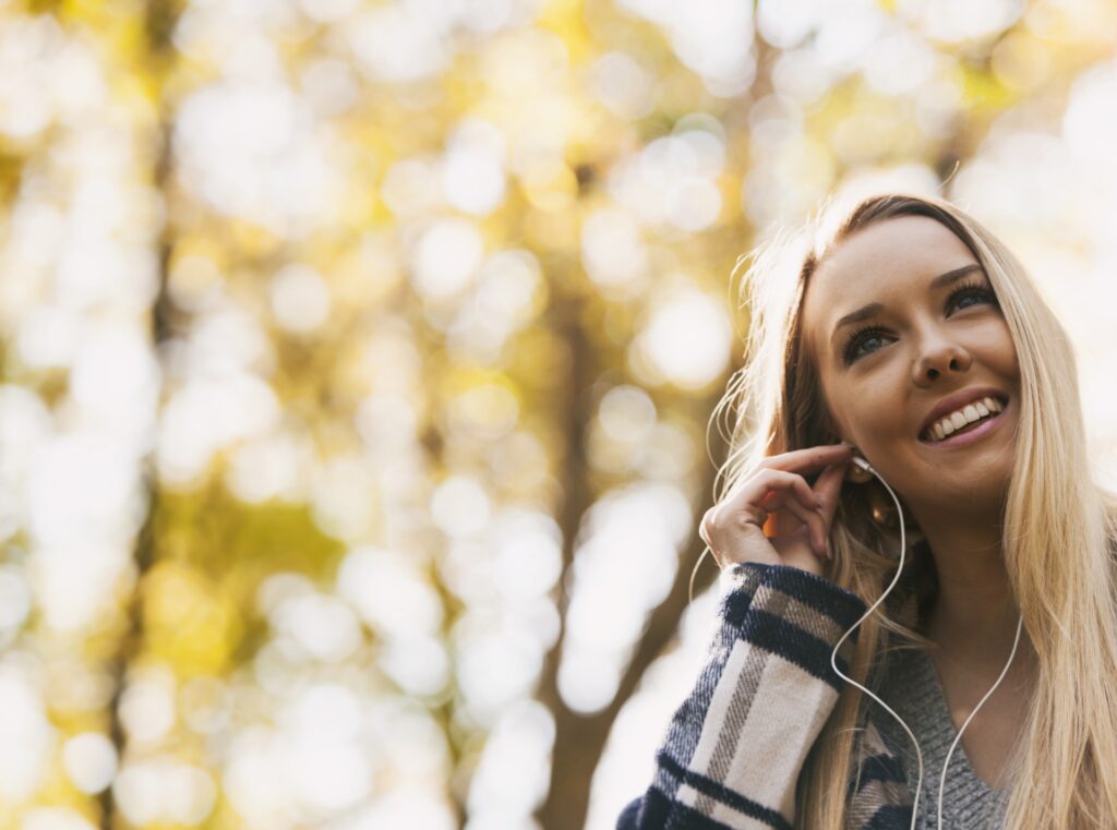 junge Frau hört Musik im Freien